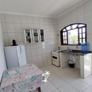 a kitchen with a refrigerator and a table in it at Apartamento dos Sonhos in Ilha Comprida