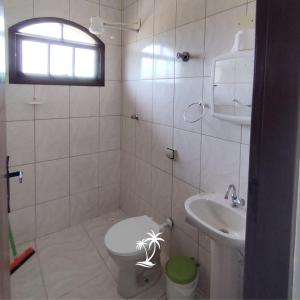 a bathroom with a toilet and a sink at Apartamento dos Sonhos in Ilha Comprida