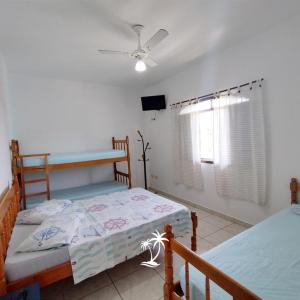 a bedroom with two bunk beds and a tv at Apartamento dos Sonhos in Ilha Comprida