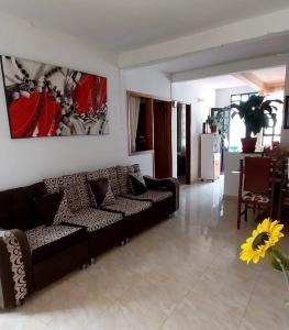 a living room with a black couch and a table at acogedora casa Rochi in Guaduas