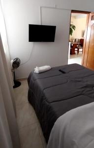 a bedroom with two beds and a flat screen tv at acogedora casa Rochi in Guaduas