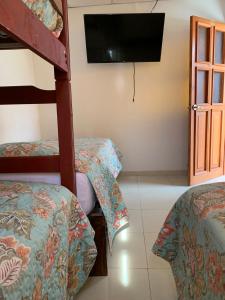 a room with two bunk beds and a flat screen tv at Hamuy's Lodge in Ica