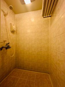 La salle de bains est pourvue d'une douche et d'un lavabo. dans l'établissement Howard Civil Service International House, à Taipei