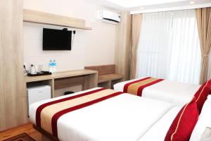Una televisión o centro de entretenimiento en Hotel Prime Suite