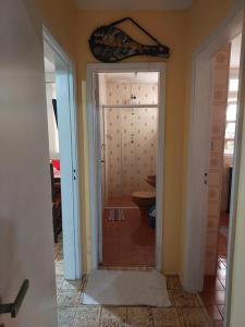 un couloir avec une porte menant à une salle de bains. dans l'établissement Apto em Pitangueiras no Guarujá para temporada, à Guarujá