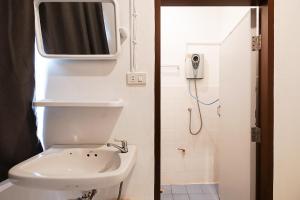 GO INN Asiatique - Charoen Krung في Godown: حمام به مرحاض وتلفزيون على الحائط