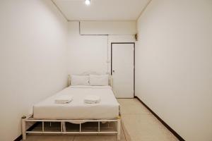 um pequeno quarto branco com uma cama em GO INN Asiatique - Charoen Krung em Godown