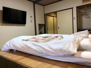 Una cama con una sábana blanca encima. en Hananoyado Fukuya, en Hakone