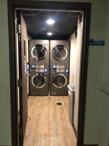 a hallway with three washing machines in a room at Universal-Disney Dream Studio 2 - The Enclave in Orlando