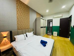 a bedroom with a large white bed with a blue object on it at JB Country Garden J Agape Homestay 2106-6A in Johor Bahru