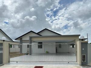 a house with a white fence in front of it at Mojisu Homestay 麻吉宿 in Miri