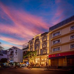 - un bâtiment dans une rue de la ville avec un coucher de soleil dans l'établissement Golden Star Apartment & Hotel, à Hô-Chi-Minh-Ville