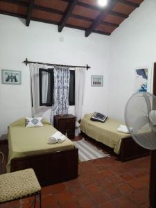 een kamer met 2 bedden en een ventilator bij La Posada de los Vallistos - Casa de Campo en El Mollar Chicoana 