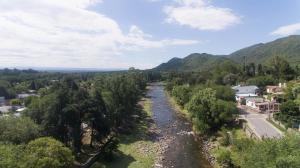 a river in a valley with trees and houses at Departamentos Valle Azul in Santa Rosa de Calamuchita
