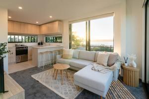 sala de estar con sofá y cocina en Harbour Haven - A Sunset Oasis! en Tauranga