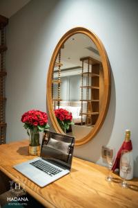 a laptop sitting on a wooden table with a mirror at Hadana Boutique Hotel Danang in Da Nang +57 photos