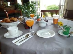 een tafel met borden eten en drinken erop bij Chambres d'hôtes Le Saleix in Donzenac