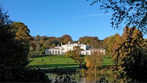 a large white house on a hill next to a lake at Charming Victorian Property in Central London in London