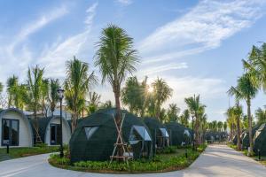 uma fileira de cúpulas verdes com palmeiras em Wonderland Resort Phan Thiet em Phan Thiet