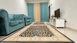 a living room with a blue couch and a rug at Homestay Anggun in Kuala Kerai