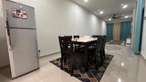 a dining room with a table and a refrigerator at Homestay Anggun in Kuala Kerai