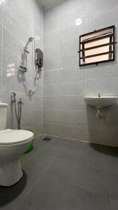 a bathroom with a shower and a toilet and a sink at Homestay Anggun in Kuala Kerai