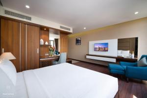 a hotel room with a bed and a desk and chairs at Hadana Boutique Hotel in Da Nang