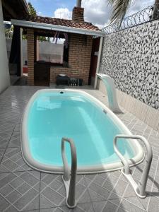 einen Pool mit 2 Stühlen und einem TV in der Unterkunft Espaço perainda in Boa Vista