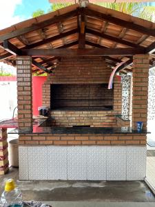 an outdoor brick fireplace with a wooden roof at Espaço perainda in Boa Vista