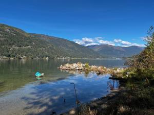 a lake with a boat in the water and mountains at Nelson, What a view, 3 bedrms, 2 Baths, full kitchen in Nelson