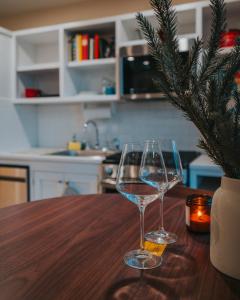 two wine glasses sitting on a wooden table with a christmas tree at Willow Pond Motel in Catskill