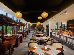 a row of tables and chairs in a restaurant at Luminor Hotel Padjadjaran Bogor by WH in Bogor