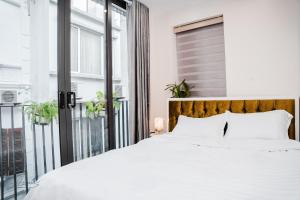河內的住宿－AimeeHouse - Trích Sài，卧室设有白色的床和大窗户