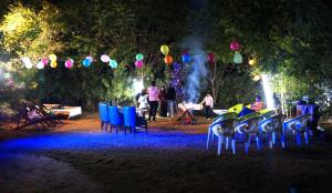 un groupe de chaises et de ballons dans un parc la nuit dans l'établissement Wow Relish, à Alwar