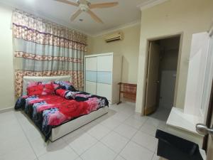 a bedroom with a bed and a ceiling fan at The Louvre Moslim Homestay Sungai Petani in Sungai Petani