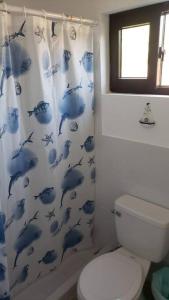 a bathroom with a blue dolphin shower curtain at Primera Casa de Contenedores en Monterrico. in Monterrico