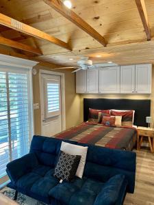 een slaapkamer met een bed en een blauwe bank bij The Lake Alfred Citruswood Cabin in Lake Alfred