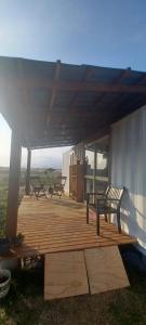 una terrazza in legno con due panche in cima a un edificio di Pousada Dunas da Imara Tiny House Conteiner. a Xangri-lá