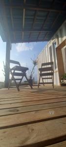 two benches sitting on top of a wooden deck at Pousada Dunas da Imara Tiny House Conteiner. in Xangri-lá