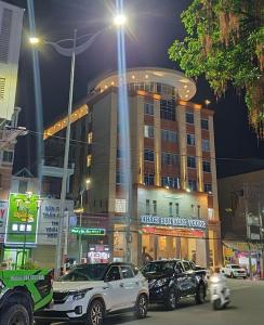Hung Vuong Hotel في كوانج نجاي: مبنى كبير فيه سيارات تقف امامه