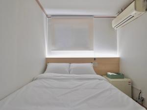 a bed in a small room with a window at J5 Hostel in Seoul