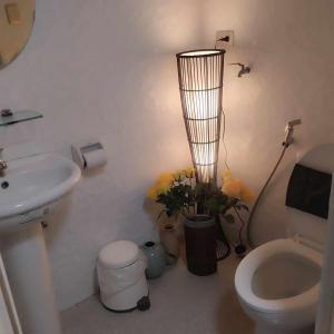 a bathroom with a sink and a toilet and flowers at Staycation at moa in Manila