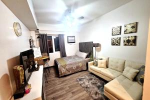 uma sala de estar com um sofá e uma cama em E Staycation Studio em Cebu