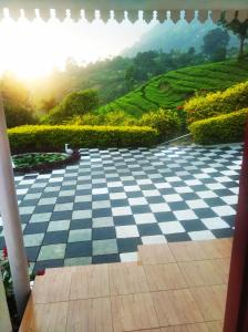 a checkered floor with a view of a tea plantation at Blackcherry Munnar in Munnar