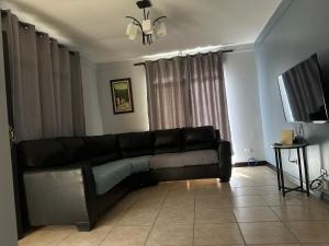 czarna skórzana kanapa w salonie z telewizorem w obiekcie Hermosa casa para descanso w mieście Linda Vista