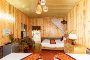 1 dormitorio con 2 camas en una habitación con paredes de madera en Hoalu Ecolodge Homestay en Ninh Binh