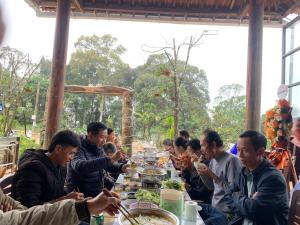 um grupo de pessoas sentadas à mesa a comer em MANG DEN Romantic em Kon Von Kla