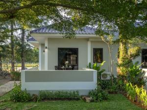 a small house with a white front porch at Isara Nai Yang resort in Nai Yang Beach