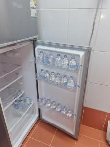 un réfrigérateur ouvert rempli de nombreuses bouteilles d'eau dans l'établissement Ayser 1, à Médine