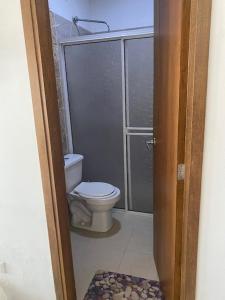 Un baño con inodoro y ducha de cristal. en Cabañas Paulamar - Apto 2 - Tolu, en La Gloria